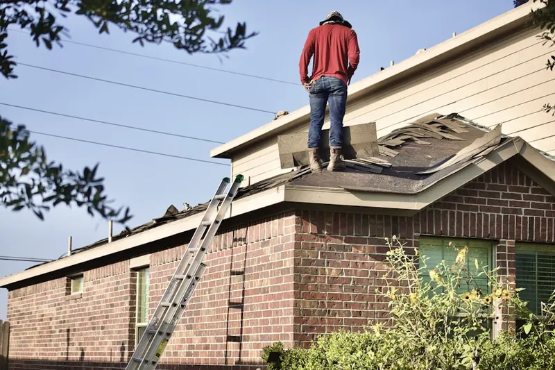 Professional roofer working on a residential roof in Dell at Muirfield